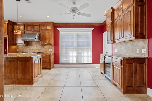 kitchen with wine cooler, light stone countertops, backsplash, and pendant lighting