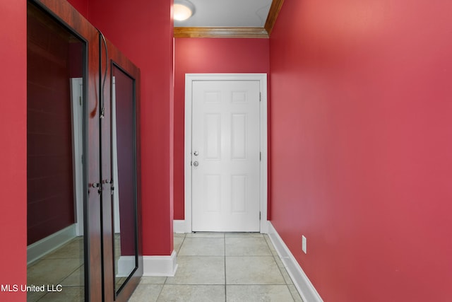 corridor with ornamental molding and light tile patterned flooring