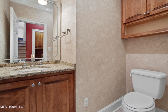 bathroom featuring vanity, toilet, and crown molding