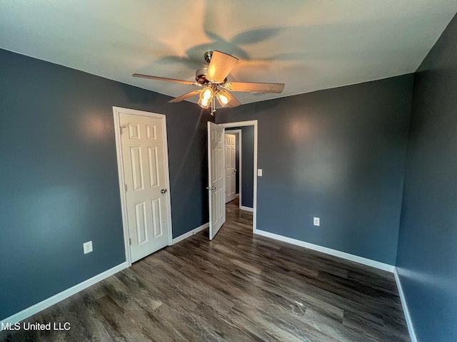 unfurnished bedroom with ceiling fan and dark wood-type flooring