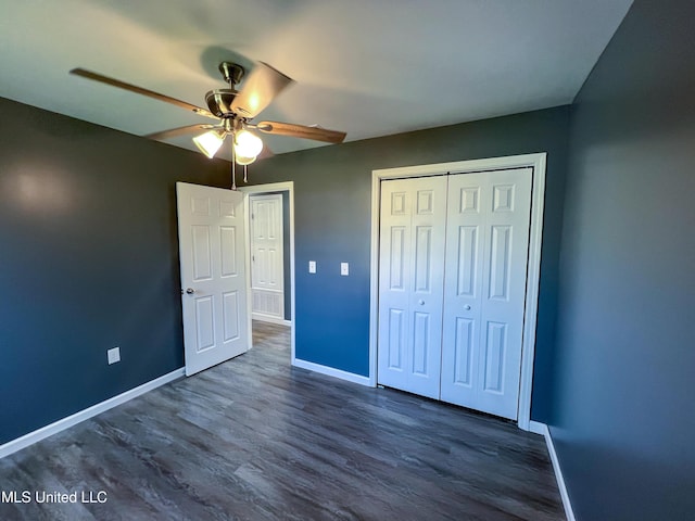 unfurnished bedroom with ceiling fan, dark hardwood / wood-style flooring, and a closet