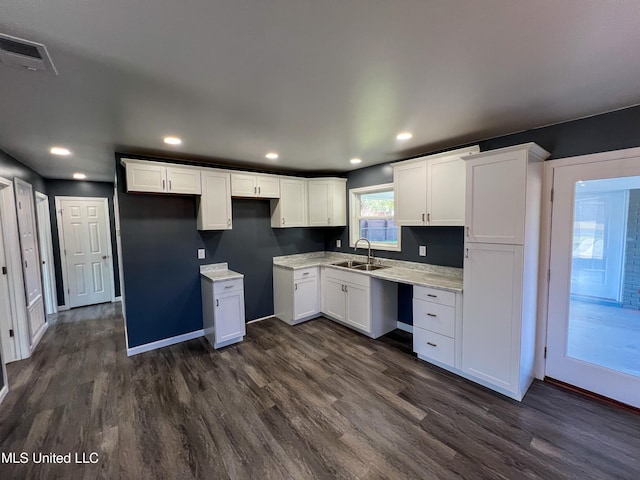 kitchen featuring light stone countertops, sink, white cabinets, and dark hardwood / wood-style floors