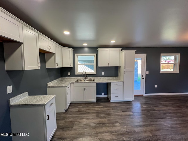 kitchen with dark hardwood / wood-style flooring, white cabinetry, sink, and plenty of natural light