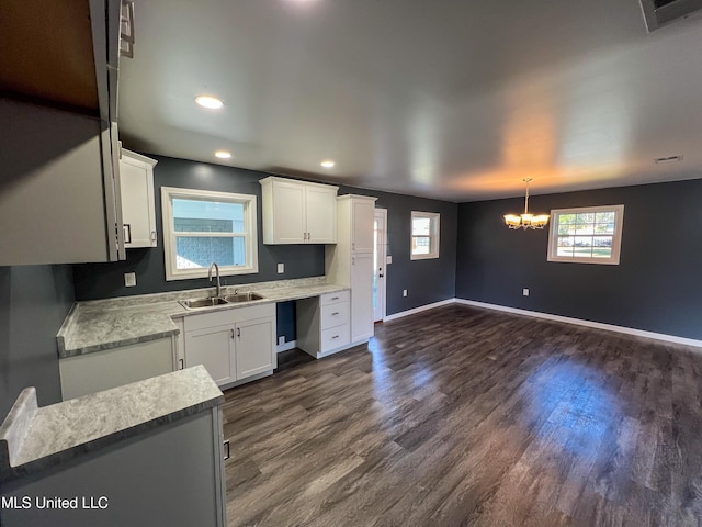 kitchen featuring pendant lighting, an inviting chandelier, white cabinets, sink, and dark hardwood / wood-style floors