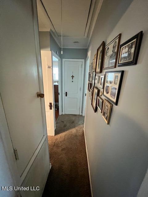 hall featuring crown molding and dark carpet