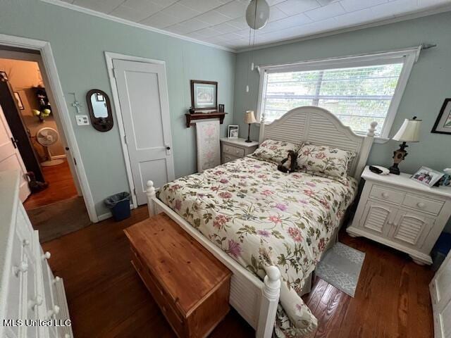 bedroom with crown molding, dark hardwood / wood-style floors, and ceiling fan