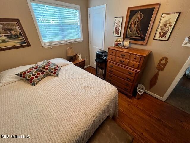 bedroom with dark hardwood / wood-style floors