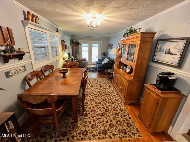 dining room with hardwood / wood-style floors and crown molding