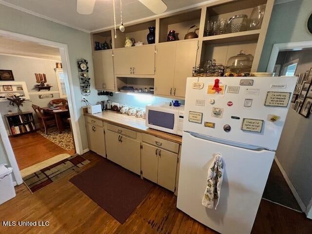 kitchen with white appliances, crown molding, dark wood-type flooring, and white cabinets