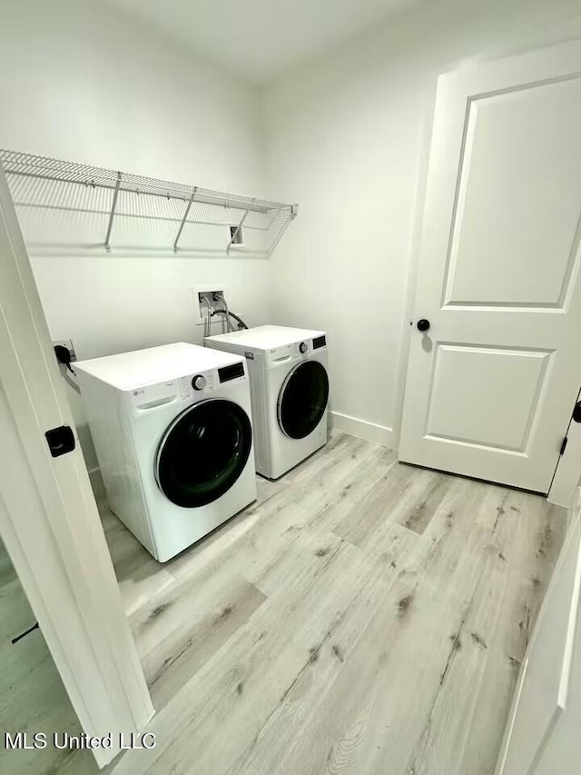 washroom featuring light hardwood / wood-style floors and washing machine and dryer