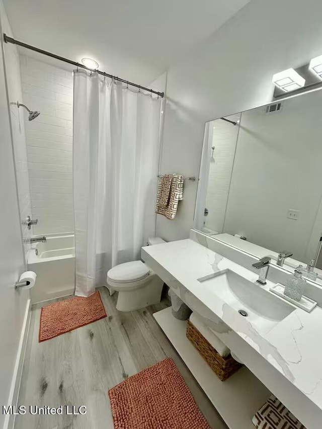 full bathroom with shower / bathtub combination with curtain, vanity, wood-type flooring, and toilet