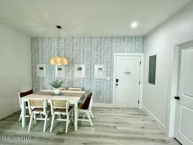 dining area with electric panel and light wood-type flooring