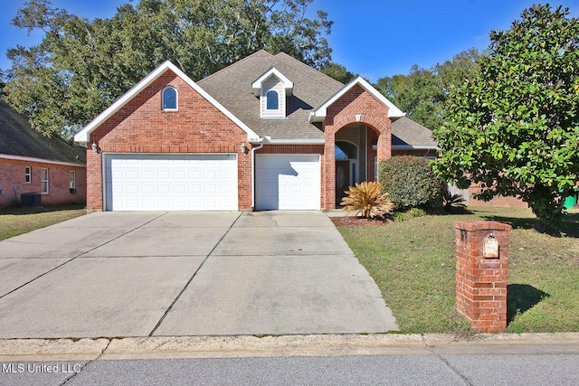 front facade with a front yard, cooling unit, and a garage