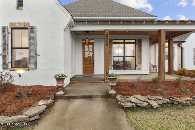 property entrance with a shingled roof and a porch