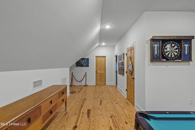 additional living space with lofted ceiling and light hardwood / wood-style flooring