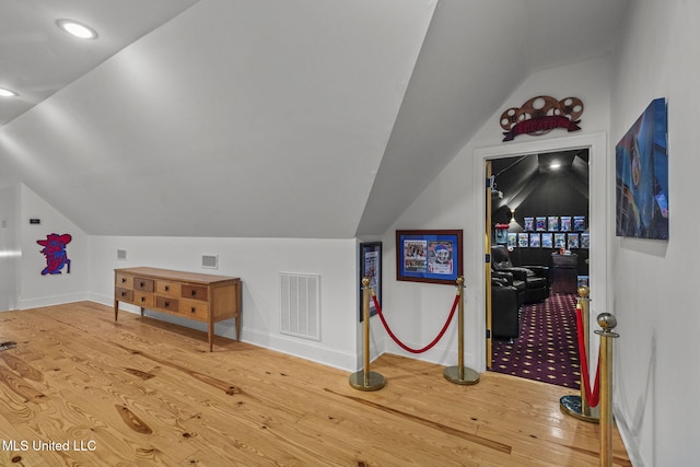 additional living space featuring hardwood / wood-style flooring and vaulted ceiling