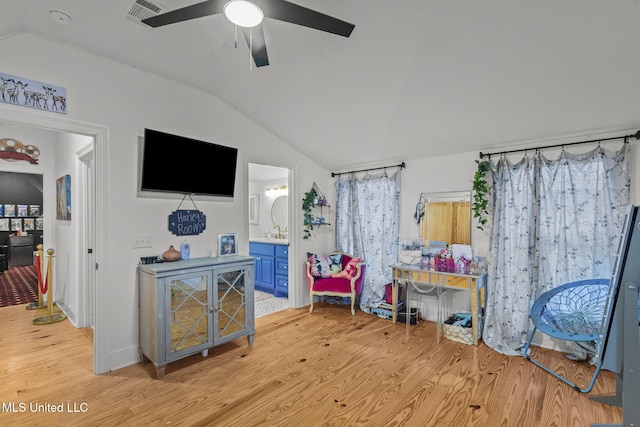 interior space with vaulted ceiling, sink, ceiling fan, and light hardwood / wood-style floors