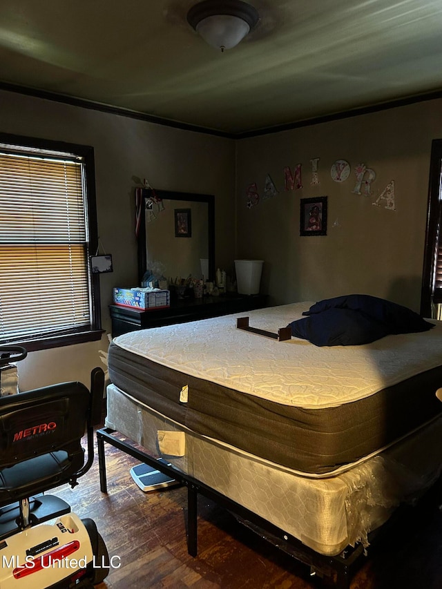 bedroom featuring crown molding and wood-type flooring