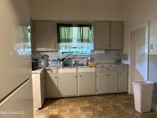 kitchen featuring tasteful backsplash, sink, and refrigerator