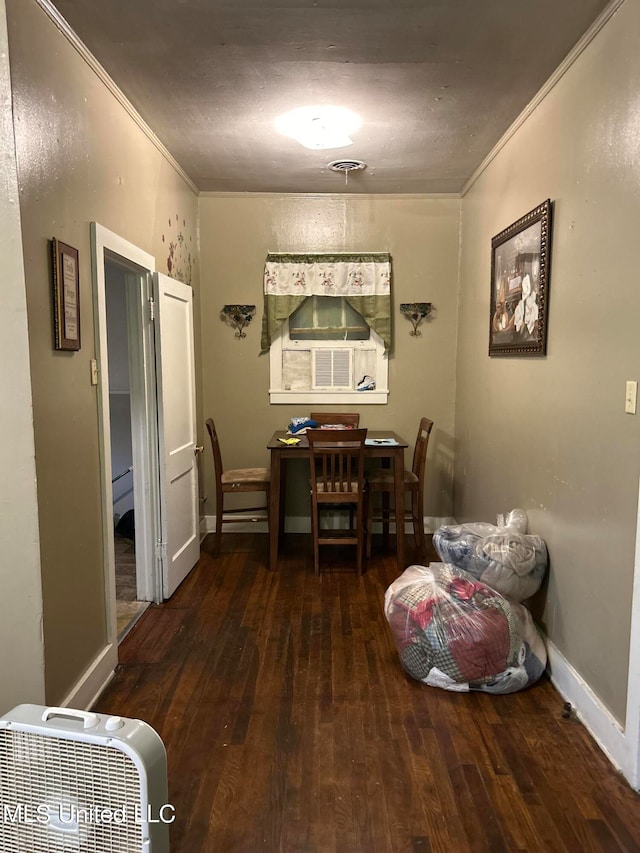 dining area with ornamental molding and dark hardwood / wood-style floors