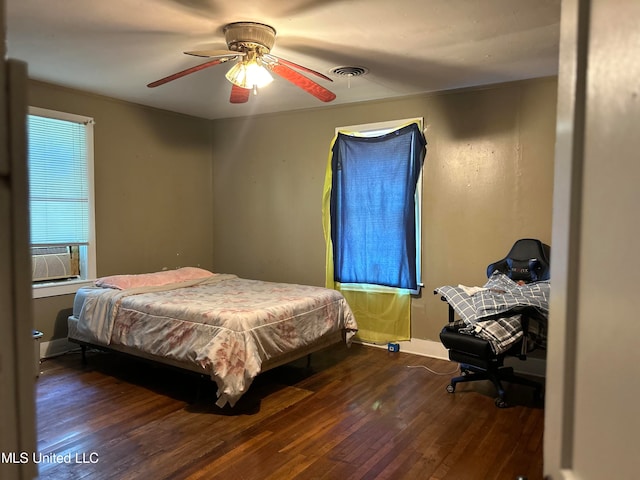 bedroom featuring dark wood-type flooring, cooling unit, and ceiling fan