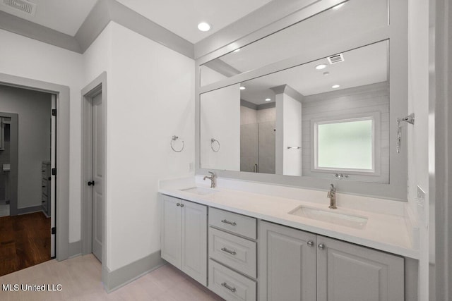 bathroom with hardwood / wood-style flooring, vanity, and walk in shower