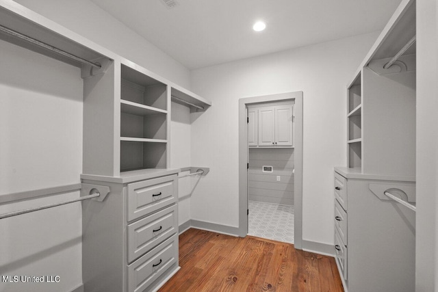 walk in closet with hardwood / wood-style flooring