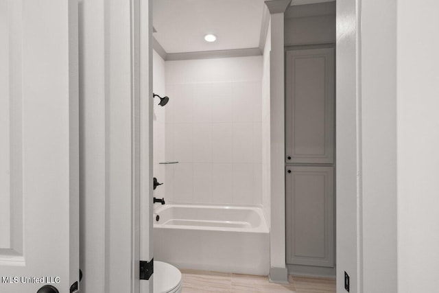 bathroom featuring tiled shower / bath combo and toilet