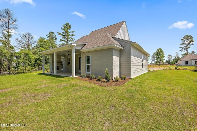 back of property with ceiling fan, a yard, and a patio