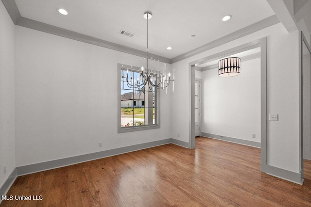 unfurnished dining area with a chandelier, hardwood / wood-style flooring, and crown molding