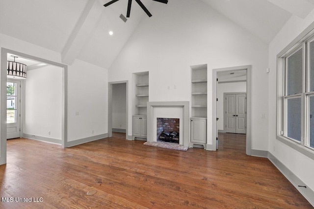 unfurnished living room featuring built in shelves, ceiling fan, high vaulted ceiling, and dark hardwood / wood-style floors