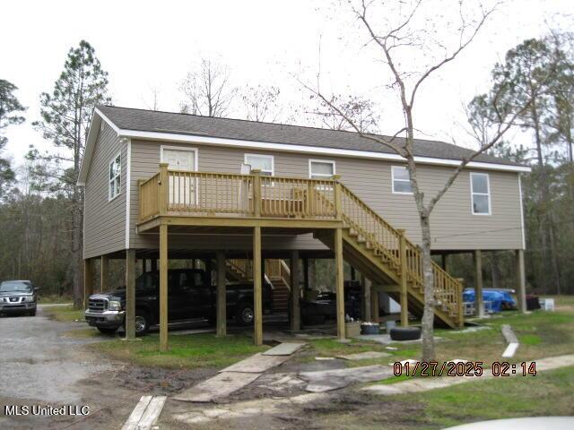 rear view of property with a wooden deck and a carport