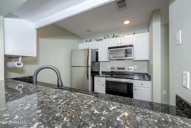 2421 Beachview Dr Unit H2, Ocean Springs, MS 39564 - kitchen with stainless steel appliances, dark stone counters, white cabinets, and recessed lighting