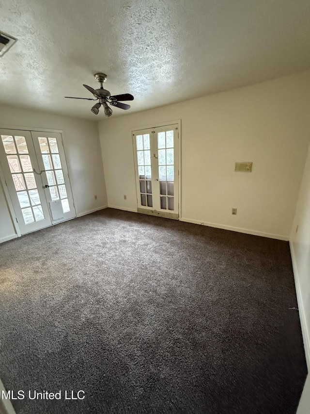 carpeted spare room with french doors, visible vents, a textured ceiling, and baseboards