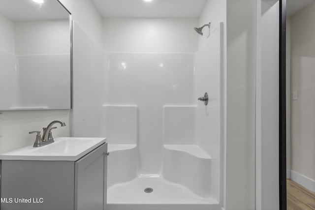 bathroom with vanity, wood-type flooring, and walk in shower