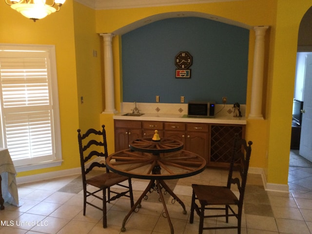 4343 Sharon Dr, Horn Lake, MS 38637 - dining room with decorative columns, arched walkways, light tile patterned floors, and baseboards
