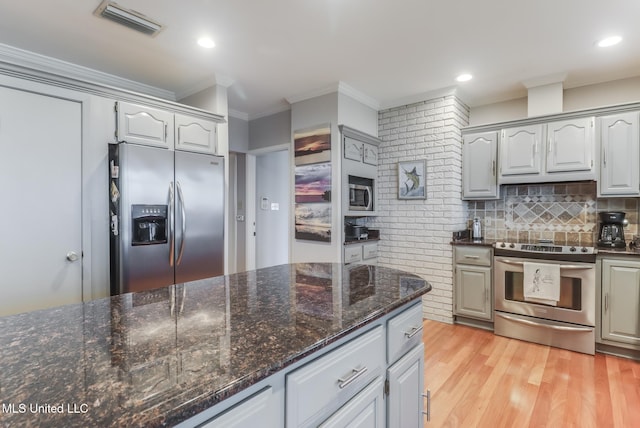 435 Christi Ln, Biloxi, MS 39531 - kitchen with stainless steel appliances, crown molding, dark stone counters, gray cabinetry, and light wood-style floors