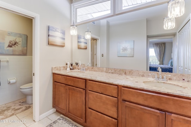 435 Christi Ln, Biloxi, MS 39531 - ensuite bathroom with double vanity, tile patterned flooring, healthy amount of natural light, and tile walls