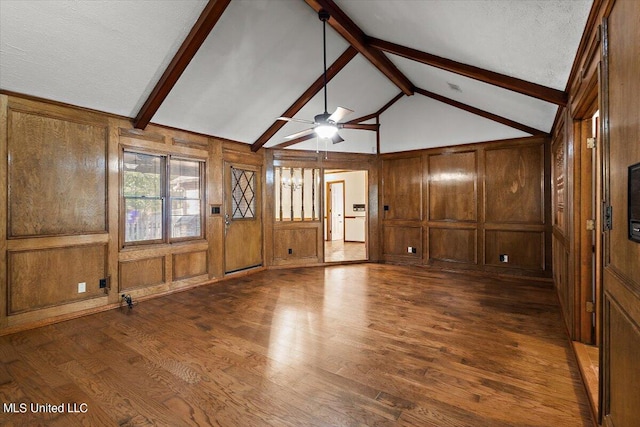 unfurnished living room featuring wood walls, a textured ceiling, and dark hardwood / wood-style flooring