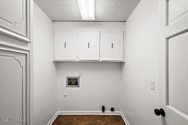 laundry area featuring a textured ceiling, cabinet space, washer hookup, and baseboards