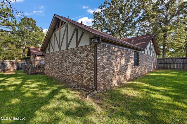 view of home's exterior featuring a yard, brick siding, and a fenced backyard