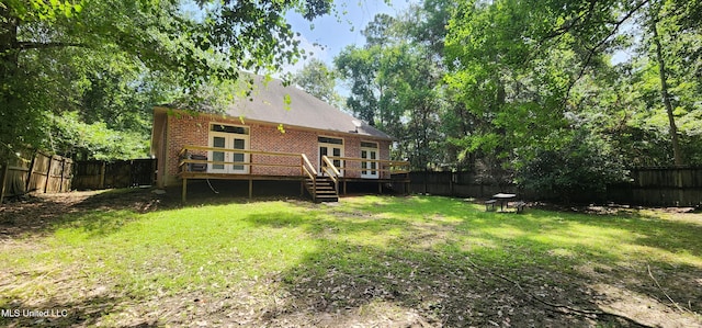 682 Hilo Way, Diamondhead, MS 39525 - rear view of house featuring brick siding, a deck, and a fenced backyard
