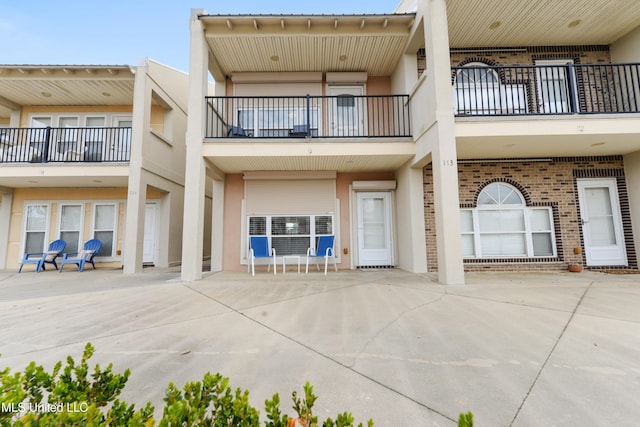 exterior space featuring stucco siding and brick siding