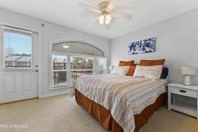 bedroom with a ceiling fan, light carpet, baseboards, and multiple windows