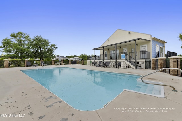 view of swimming pool featuring a patio area, fence, and a fenced in pool