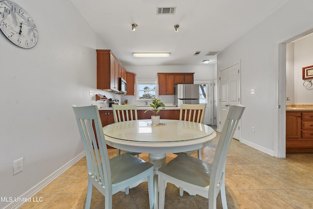 dining space with light tile patterned flooring, visible vents, and baseboards