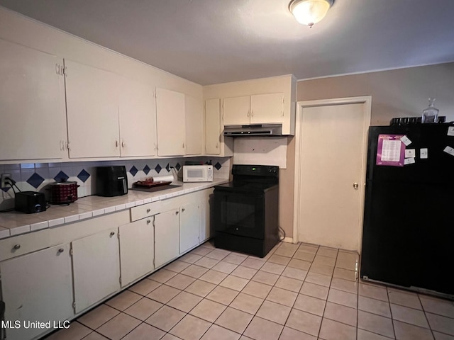 206 Shields Ave, Pelahatchie, MS 39145 - kitchen with black appliances, under cabinet range hood, tile counters, and white cabinetry