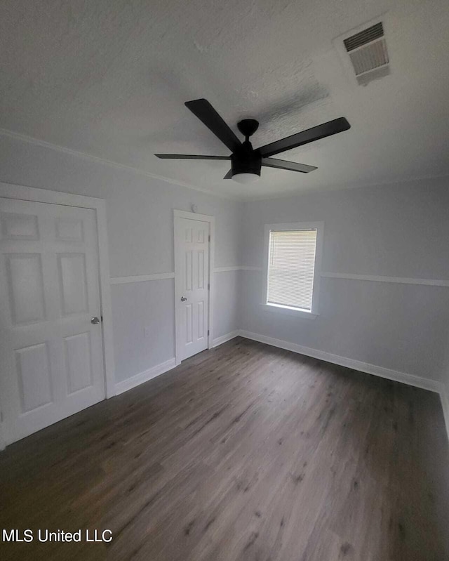 unfurnished room with a textured ceiling, ceiling fan, and dark hardwood / wood-style flooring