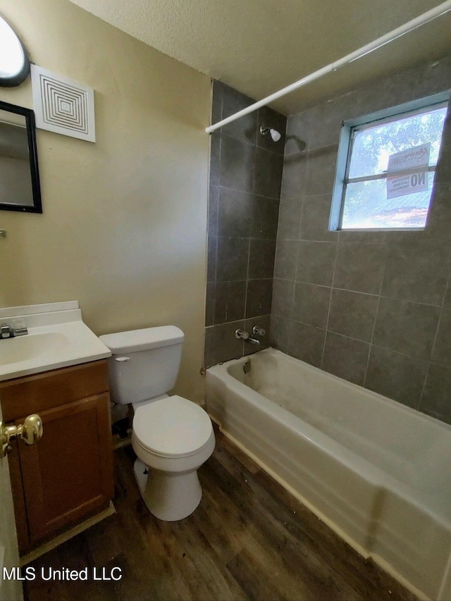 full bathroom featuring vanity, toilet, tiled shower / bath combo, and wood-type flooring