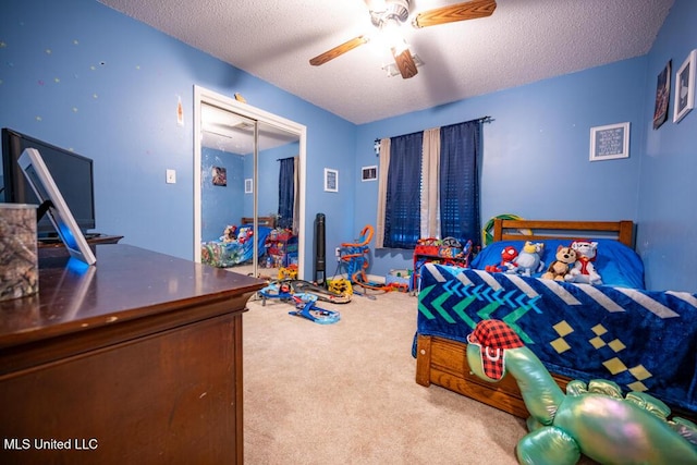 bedroom featuring a textured ceiling, ceiling fan, a closet, and carpet floors